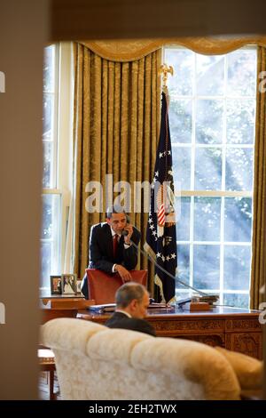 Präsident Barack Obama ruft Senatoren aus dem Oval Office an. Februar 6 2009. Phil Schiliro, Assistent des Präsidenten für Legislative Angelegenheiten, sitzt. Stockfoto