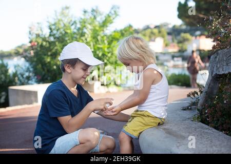 Kinder, Jungen Brüder, Masken tragen und Desinfektion im Freien Stockfoto