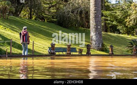 Frau zu Fuß in Terra Nostra Park, in der Nähe von Thermalwasser-Pool, Azoren Reiseziel, Sao Miguel Insel. Stockfoto