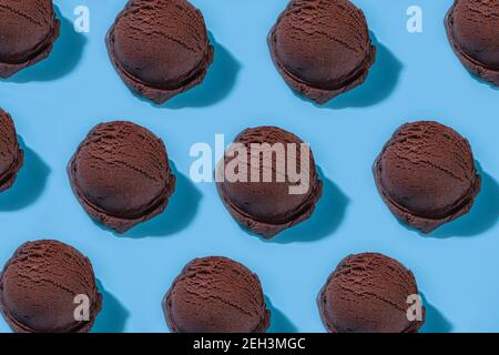 Bunte verschiedene Eisbecher Muster auf pastellblauem Hintergrund. Sommer Minimalismus Muster flach Lay mit hartem Licht. Schokolade Vanille Blaubeere s Stockfoto