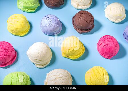 Bunte verschiedene Eisbecher Muster auf pastellblauem Hintergrund. Sommer Minimalismus Muster flach Lay mit hartem Licht. Schokolade Vanille Blaubeere s Stockfoto