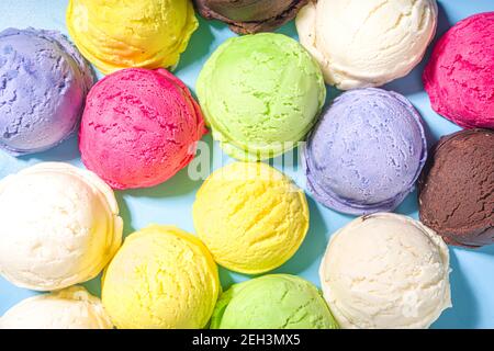 Bunte verschiedene Eisbecher Muster auf pastellblauem Hintergrund. Sommer Minimalismus Muster flach Lay mit hartem Licht. Schokolade Vanille Blaubeere s Stockfoto