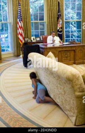 5. August 2009 „Ich saß im Empfangsbereich außerhalb des Oval Office, als Sasha vorbeiging und zum Oval ging. Ich vermutete, dass etwas oben war, also folgte ich ihr. Sasha kroch dann ins Büro, versteckte sich hinter dem Sofa, und als sie das andere Ende erreichte, sprang sie auf und schrie, ihren Vater zu sprießen.“ Stockfoto