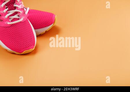 Sport-Sneaker, rosa auf gelbem Hintergrund mit freiem Platz. Blick von oben, minimalistisches Konzept Stockfoto