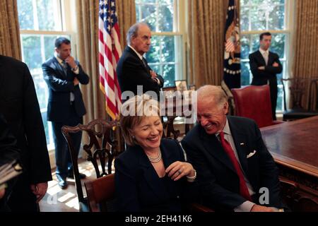 Außenministerin Hillary Rodham Clinton lacht über eine Bemerkung von Vizepräsident Joe Biden, als sie auf den Beginn einer Presseerklärung von Präsident Barack Obama und dem ägyptischen Präsidenten Hosni Mubarak im Oval Office am 18. August 2009 warten. Stockfoto