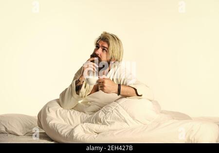 Start Tag mit gutem Kaffee. Gourmet-Espresso. Genießen Sie den morgendlichen Kaffee. Schöner Mann trinkt Kaffee. Reifer bärtiger Mann im Bett. Der Körper wurde von wesentlichen Komponenten für eine gute Gesundheit und Energie beraubt. Stockfoto
