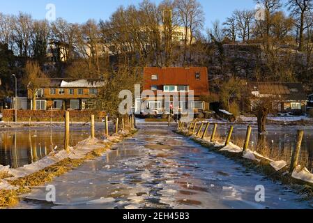 WAGENINGEN, NIEDERLANDE - 13. Feb 2021: Eisige Straße nach Hochwasser in den Flutflächen des Rheins bei Wageningen Stockfoto