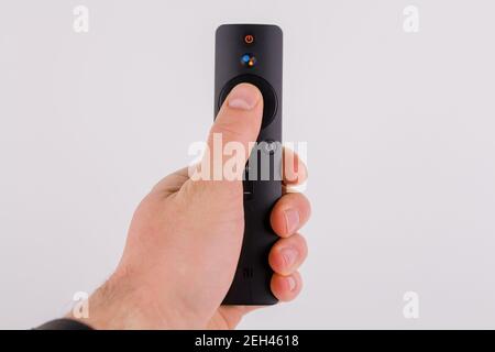 Eine moderne Fernbedienung von einem Smart-TV in einem Hand des Mannes auf weißem Hintergrund Stockfoto