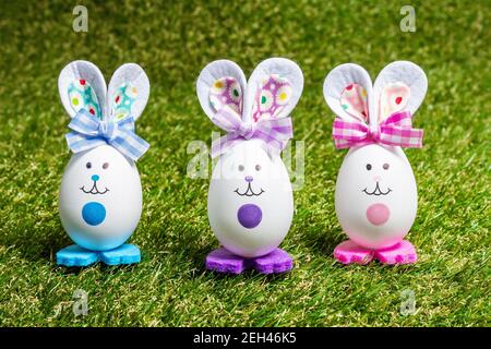 Traditionelles festliches Osterkonzept. Bunte niedliche handgemachte Kaninchen aus Eiern auf grünem Gras Hintergrund, kopieren Raum Stockfoto