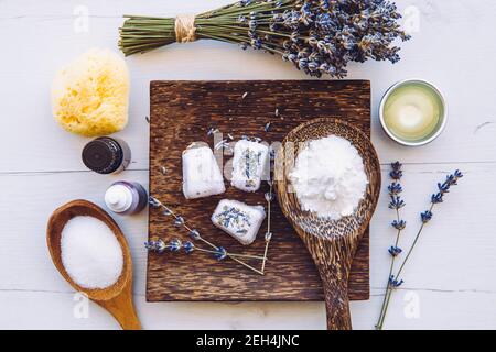 Flach Lay Blick auf kleine Würfel Form Bad fizzies auf Holz Tablett, umgeben von Zutaten. Machen hausgemachte kleine Bad fizzy. Stockfoto