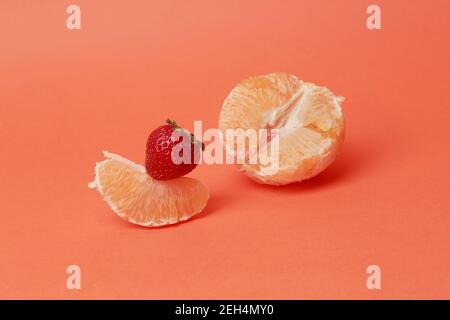 Orange und Erdbeere auf einem Farbblock Hintergrund Stockfoto