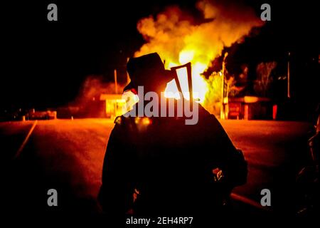 Michael Bunel / Le Pictorium - Ukraine Donbass-Krieg - 22/05/2014 - Ukraine / Donbass / Semenivka - EIN separatistischer Soldat nähert sich nach der Bombardierung der Stellungen durch die ukrainische Armee einem brennenden Haus. 22.Mai 2014. Semeniwka. Ukraine. Stockfoto