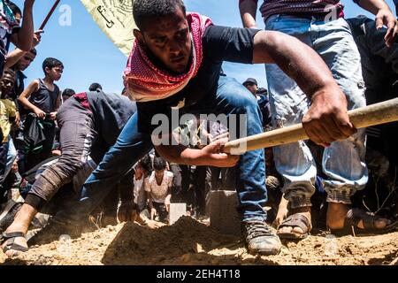 Freunde und Familie bei der Beerdigung von Jamal Affana (15), nachdem er einer Schusswunde erlag, die bei den Protesten am vergangenen Freitag am Grenzzaun zu Gaza mit Israel am 13. Mai 2018 in Rafah, Gaza, erlitten wurde. Affana wurde am Freitag von einem israelischen Scharfschützen getötet, während er an den Demonstrationen teilnahm. Für die 1,9 Millionen Palästinenser, die im Gazastreifen leben, ist das Leben nach 10 Jahren israelischer Blockade zu einem täglichen Kampf um Nahrung, Strom und Geld geworden. Die Proteste haben bisher 40 Palästinenser getötet und über 1.700 durch den Beschuss der israelischen Armee verletzt. Die Hamas-Herrscher von Gaza haben dies gelobt Stockfoto