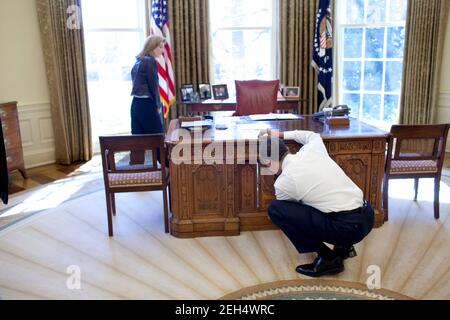 Präsident Barack Obama untersucht den Resolute Desk am 3. März 2009 bei einem Besuch bei Caroline Kennedy Schlossberg im Oval Office. In einer berühmten Fotografie guckte ihr Bruder John F. Kennedy Jr. durch das FDR-Panel, während sein Vater Präsident Kennedy arbeitete. Stockfoto