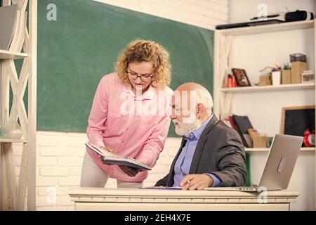 Bitte helft mir. Hausaufgaben überprüfen. Student fragt Lehrer nach Aufgabe. Erzieher und Schüler, die Buch betrachten. Erläuterung schwieriger Informationen. Mathematische Aufgaben lösen. Quellenkenntnisse buchen. Schulbuchkonzept. Stockfoto