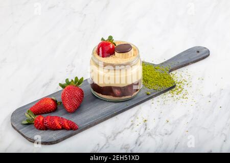 Erdbeere und Bananenmagnolie Dessert in der Tasse Baum Magnolie auf dem hellen Marmor Hintergrund. Stockfoto