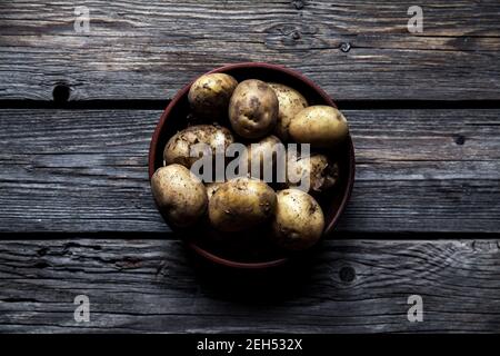 Rohe Kartoffeln in Schale auf Holztisch. Nähe zu sehen. Stockfoto