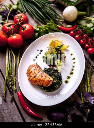 Gebackenes Lachssteak mit Spinat und Zitronenscheibe Stockfoto
