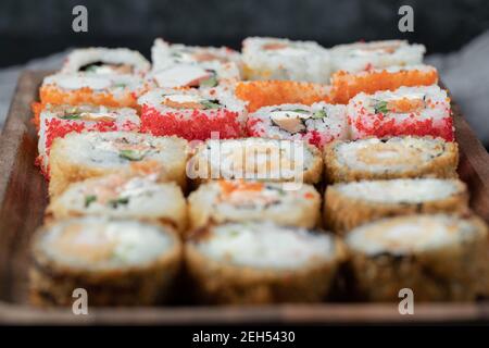 Sushi-Set auf einem Holzbrett mit gemischten Zutaten Stockfoto