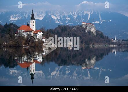 Bled, Slowenien. Februar 2021, 19th. Die Kirche Mariä Himmelfahrt auf der Insel Blejski Otok im Bleder See am Fuße der Pokljuka-Hochebene. Im Hintergrund ist die Burg Bled zu sehen. Die Biathlon-Weltmeisterschaft findet vom 10-21. Bis 22. Februar in Pokljuka statt. Quelle: Sven Hoppe/dpa/Alamy Live News Stockfoto