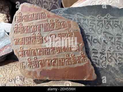 Mani Wand und Stein mit buddhistischen Symbolen Stockfoto