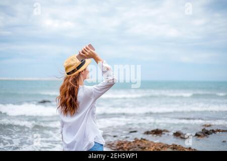 Frau wirft Handy in den Strand. Stockfoto