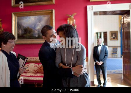 Präsident Barack Obama umarmt First Lady Michelle Obama im Red Room während Senior Advisor Valerie Jarrett Lächeln vor der nationalen Zeitung Publishers Association (NNPA) Rezeption 20.03.09.  Offiziellen White House Photo by Pete Souza Stockfoto