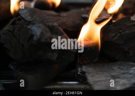 Glühende Grill Holzkohle Briketts in einem BBQ Kohle Feuerzeug. Feuerflamme wird mit Feuerstartern unter Holzkohle in der Grillkohle g platziert gestartet Stockfoto