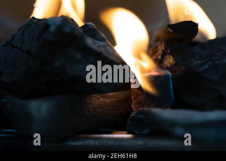 Glühende Grill Holzkohle Briketts in einem BBQ Kohle Feuerzeug. Feuerflamme wird mit Feuerstartern unter Holzkohle in der Grillkohle g platziert gestartet Stockfoto