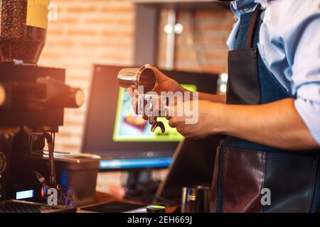 Barista hält einen Portafilter und Kaffee macht Kaffee im Café. Stockfoto