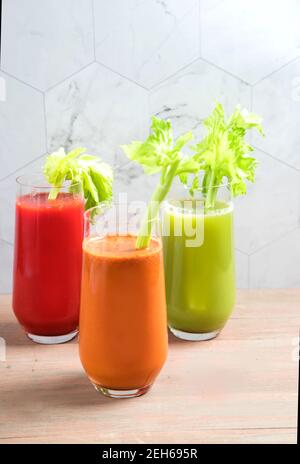 Drei Tassen natürliche Säfte aus frischem Gemüse, Tomaten, Sellerie und Karotten mit Sellerie-Blättern. Gesunde Getränke, Copy Space Stockfoto