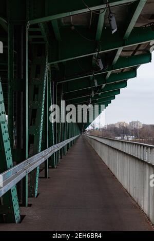 Lange Holz- und Metallbrücke mit Straßenbahnschienen und grün Konstruktion Stockfoto