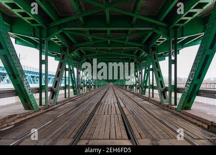 Lange Holz- und Metallbrücke mit Straßenbahnschienen und grün Dach Stockfoto