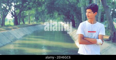 Mann aus dem Nahen Osten mit einem Verband an der Hand posiert Im Park Stockfoto