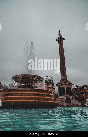 London UK Januar 2021 Vertikale Aufnahme der Trafalgar Square Säule, Wasserbrunnen, der Wasser in hohe Höhen spritzt. Stockfoto
