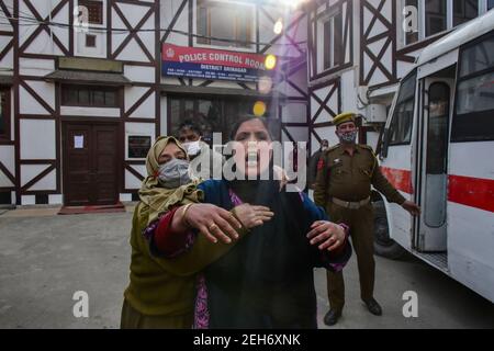 Srinagar, Indien. Februar 2021, 19th. Eine Polizistin tröstet einen trauernden Verwandten des Verstorbenen während einer Kranzniederlegung für die beiden Polizisten, die bei einem militanten Angriff in Srinagar getötet wurden. Zuvor wurden drei Militante und ein Polizist bei zwei getrennten Begegnungen im Kaschmir-Tal getötet. Kredit: SOPA Images Limited/Alamy Live Nachrichten Stockfoto