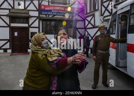 Srinagar, Indien. Februar 2021, 19th. Eine Polizistin tröstet einen trauernden Verwandten des Verstorbenen während einer Kranzniederlegung für die beiden Polizisten, die bei einem militanten Angriff in Srinagar getötet wurden. Zuvor wurden drei Militante und ein Polizist bei zwei getrennten Begegnungen im Kaschmir-Tal getötet. Kredit: SOPA Images Limited/Alamy Live Nachrichten Stockfoto