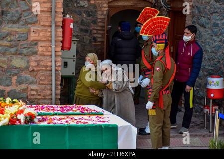 Srinagar, Indien. Februar 2021, 19th. Eine Polizistin tröstet einen trauernden Verwandten des Verstorbenen während einer Kranzniederlegung für die beiden Polizisten, die bei einem militanten Angriff in Srinagar getötet wurden. Zuvor wurden drei Militante und ein Polizist bei zwei getrennten Begegnungen im Kaschmir-Tal getötet. Kredit: SOPA Images Limited/Alamy Live Nachrichten Stockfoto