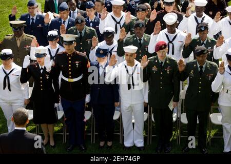 Präsident Barack Obama sieht zu, wie aktive Dienstmitglieder den Bundeseid der Vereinigten Staaten während einer Einbürgerungszeremonie im Rosengarten des Weißen Hauses am 23. April 2010 ablegen. Stockfoto