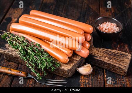 Frankfurter Würstchen auf Holzschneidebrett. Dunkler Holzhintergrund. Draufsicht Stockfoto