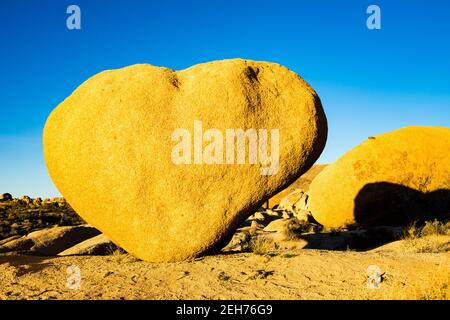 Herzförmiger Felsblock im goldenen Abendlicht im Joshua Tree National Park, CA. Valentinskarte angemessen. Rock solide Liebe Konzept. Stockfoto