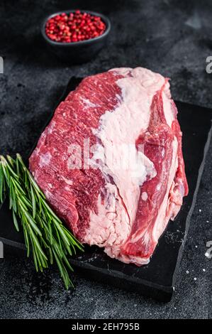 Außen roh Rundes Rinderbraten auf Marmorplatte geschnitten. Schwarzer Hintergrund. Draufsicht Stockfoto