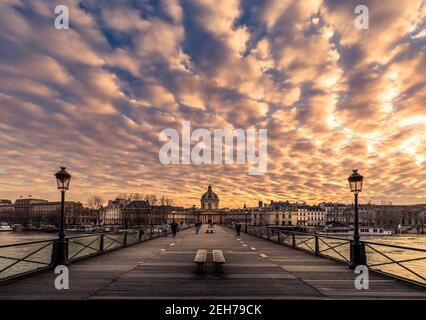 Paris, Frankreich - 12. Februar 2021: Paris Holzbank auf Pont des Arts Holzbrücke bei Sonnenuntergang Stockfoto