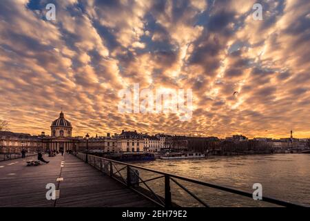 Paris, Frankreich - 12. Februar 2021: Paris Holzbank auf Pont des Arts Holzbrücke bei Sonnenuntergang Stockfoto