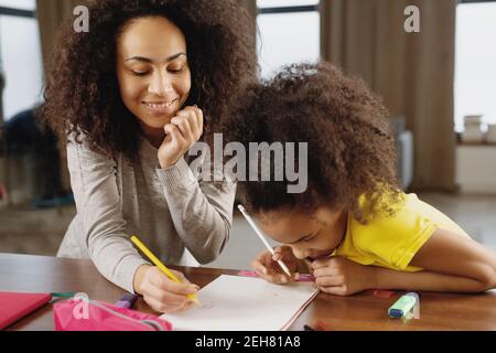 Mutter und Tochter machen gemeinsam Hausaufgaben zu Hause. Stockfoto