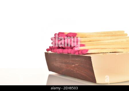 Eine Papierkiste mit Holzpasthölzern auf weißem Hintergrund. Stockfoto