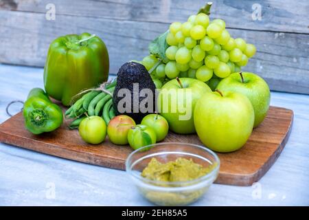 Grünes Gemüse und Obst auf einem Schneidebrett Stockfoto