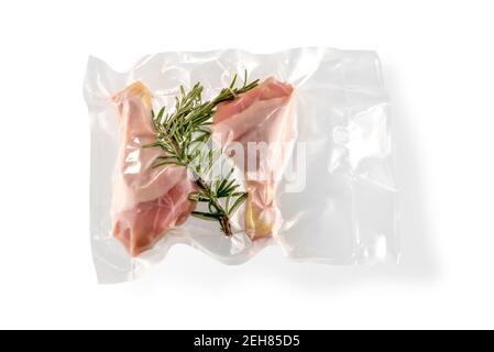 Hähnchenschenkel und Rosmarin im Vakuum verpackt versiegelt für Sous Vide Kochen, isoliert auf weißem Hintergrund Stockfoto
