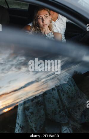 Hintergrund von Mann und Frau sitzen in einem Auto mit Platz für Ihren Text. Junges Paar in einem Auto Stockfoto