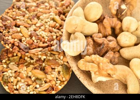 Mehrere ganze frische, duftende, köstliche nussige Kekse liegen zusammen mit natürlichen Nüssen, Nahaufnahme, auf einem Schiefertafel. Stockfoto